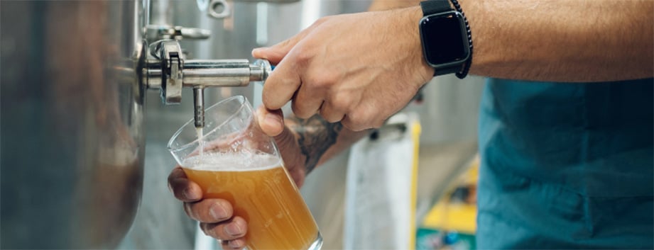 Bartender pouring beer from a tap into a pint glass