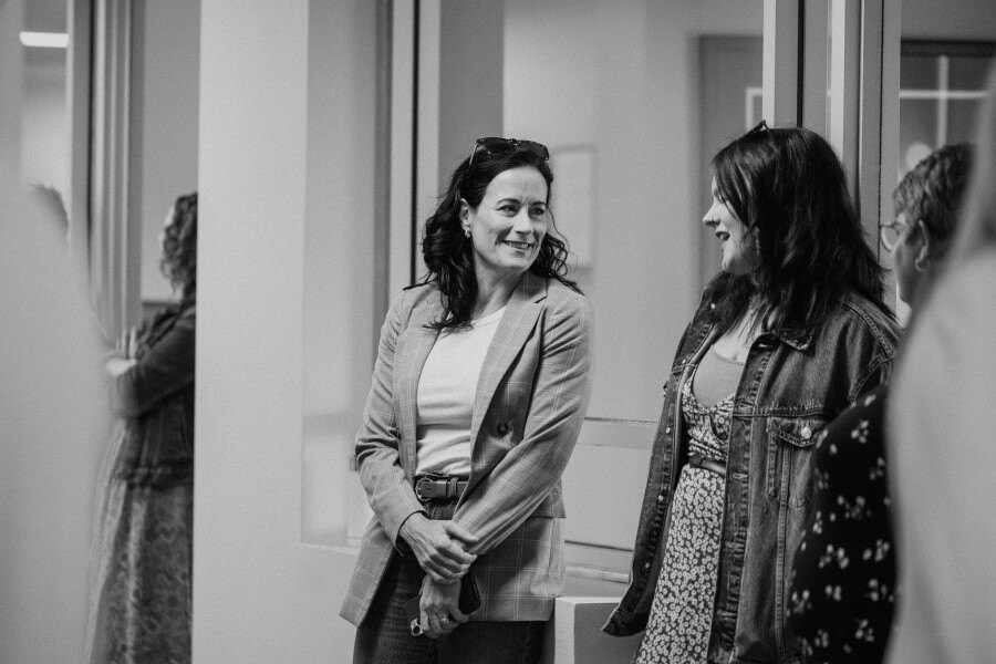 Black and White photo of Vision33 team members talking in the office